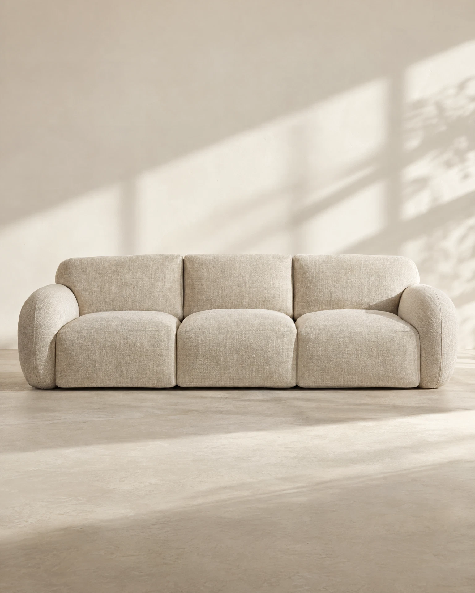 Oatmeal linen sofa in a warm editorial studio setting